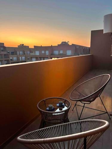马拉喀什NOUR appartement的阳台上的两把椅子和一张桌子