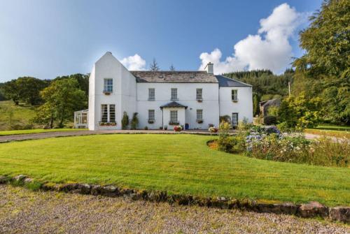 a large white house with a large yard at Killean Farmhouse B&B in Inveraray