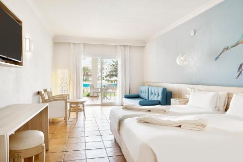 Iberostar Founty Beach All Inclusive في أغادير: غرفة فندقية بسريرين ومكتب