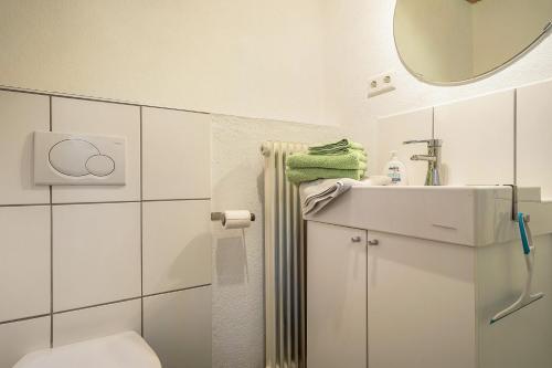 a bathroom with a sink and a toilet and a mirror at Tobelbach in Weiler-Simmerberg