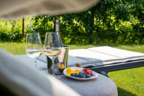 a table with two glasses of wine and a plate of fruit at Relais La Dolce Vite in San Vendemiano