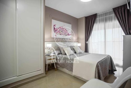 ein Schlafzimmer mit einem Bett, einem Tisch und einem Stuhl in der Unterkunft Casa Orión Ivan Luxury Homes 3ªPta Frontal 1ªLínea in Oropesa del Mar