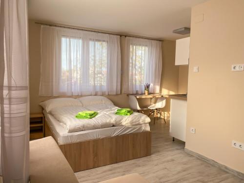 a bedroom with a bed with green towels on it at Fasor Vendégház in Szeged