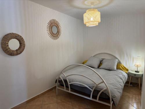 - une chambre blanche avec un lit et un miroir dans l'établissement Grande annexe de maison avec jardin, à Aix-en-Provence