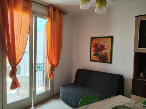 a living room with a couch and a window at Bilo Olivieri Porto Cesareo in Porto Cesareo