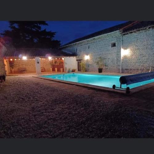 une piscine devant un immeuble la nuit dans l'établissement Honeysuckle Cottage at Gites de la Vienne, à Chaunay