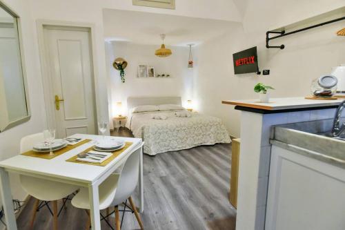 a bedroom with a bed and a table and a kitchen at Welcome Varigotti - Borgo Saraceno - Tramontana in Varigotti