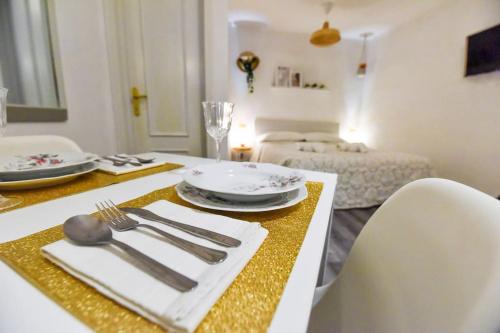 - une table à manger avec des assiettes et des ustensiles dans l'établissement Welcome Varigotti - Borgo Saraceno - Tramontana, à Varigotti