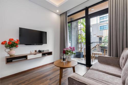 a living room with a couch and a tv at Chi House Danang Hotel and Apartment in Da Nang