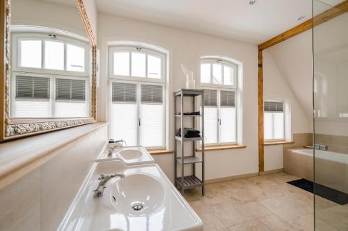 La salle de bains est pourvue d'un lavabo et d'un miroir. dans l'établissement Landhaus Waldstrasse 7, à Hermannsburg