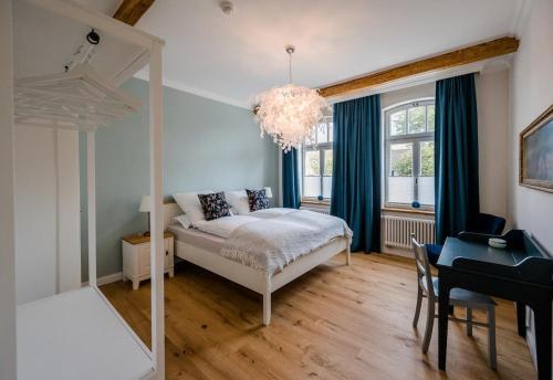 - une chambre avec un lit et un lustre dans l'établissement Landhaus Waldstrasse 7, à Hermannsburg