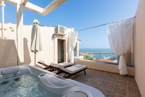 a bath tub in a room with a view of the ocean at Penelope Home in Panormos Rethymno