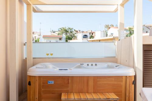 a bathroom with a sink and a large window at Beachfront Penelope Home with Private Jacuzzi, BBQ & Playground, Walk to Everything in Panormos Rethymno
