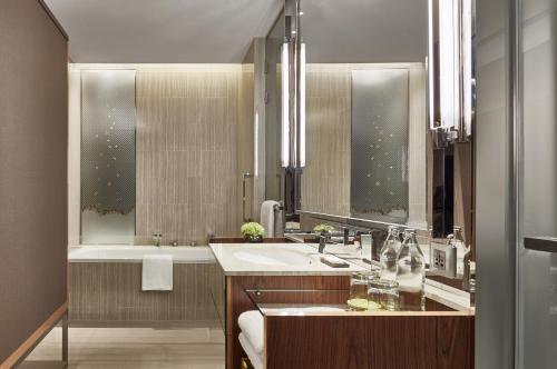 a bathroom with a sink and a bath tub at Hyatt Regency Bangkok Sukhumvit in Bangkok