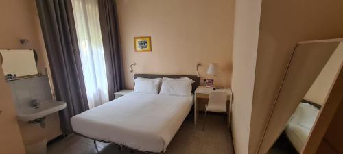 a hotel room with a white bed and a table at Villa Riari Garden in Rome