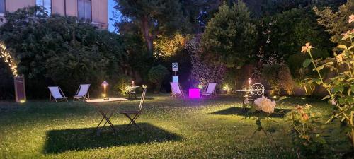un patio con sillas y luces en el césped en Villa Riari Garden, en Roma