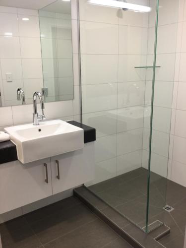 a bathroom with a sink and a glass shower at East Pier Hotel in Napier