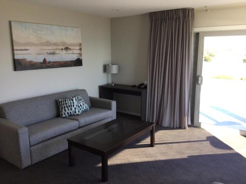 a living room with a couch and a coffee table at East Pier Hotel in Napier