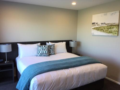 a bedroom with a bed with a blue blanket at East Pier Hotel in Napier