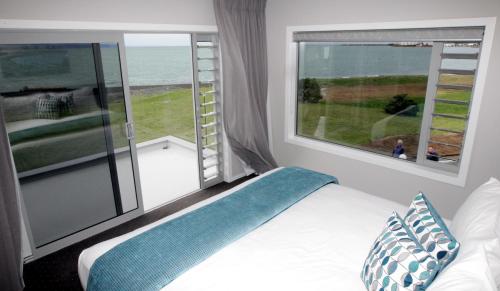 een slaapkamer met een bed en een groot raam bij East Pier Hotel in Napier