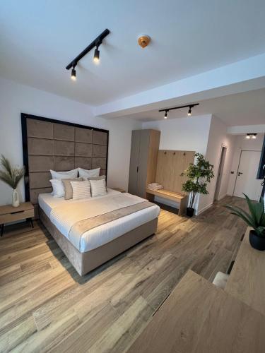 1 dormitorio con 1 cama grande y suelo de madera en Atmosphere by the Sea en Eforie Nord