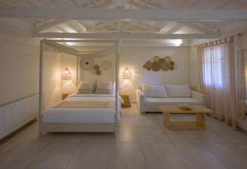 a bedroom with a bed and a couch and a table at Oikies Small Elegant Houses in Mytilene
