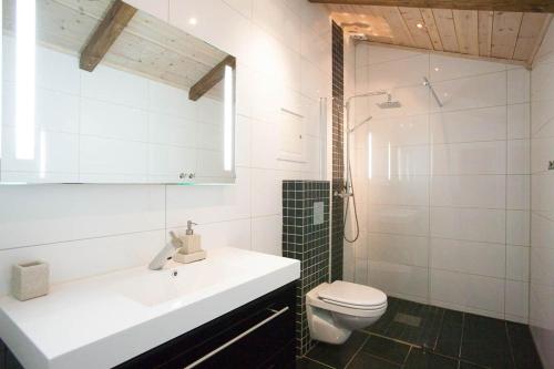a white bathroom with a sink and a toilet at Luxury cabin in the mountains with all facileties in Sønstebø
