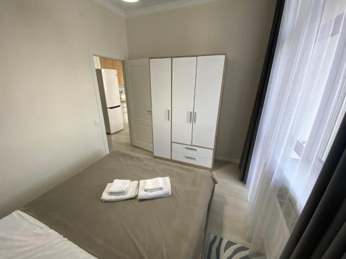una camera da letto con un letto e due asciugamani di Alau Apartments a Astana