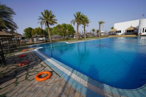 una gran piscina con un anillo naranja. en Palm Beach Resort, en Bahía de la Media Luna