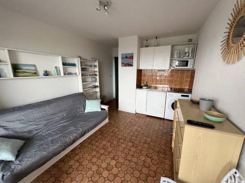 un petit salon avec un canapé et une cuisine dans l'établissement Appartement en bord de mer pour 4 pers., parking privé, proche commerces, plage sans route à traverser - FR-1-81-374, à Port-Leucate