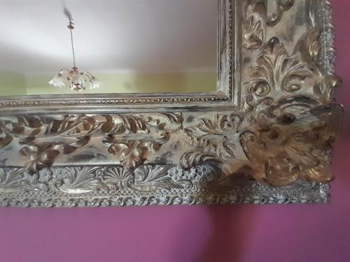 an ornate gold mirror hanging on a wall at Georgia's Village House in Kondóstavlos