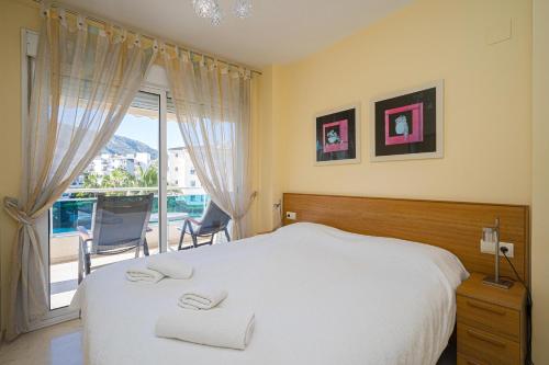 1 Schlafzimmer mit einem weißen Bett und einem Balkon in der Unterkunft Estrella 2 3a Spaniahome in L'Alfas del Pi