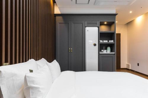 a bedroom with a bed with white pillows at Hotel Demer Mokpo in Mokpo