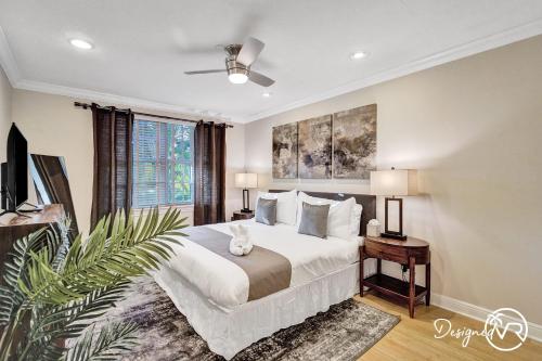 een slaapkamer met een groot wit bed en een plant bij Fabulous 4BR home close to beach in Fort Lauderdale