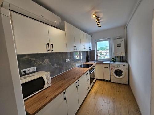 札勒烏的住宿－Modern Residence Scala，厨房配有白色橱柜和木制台面