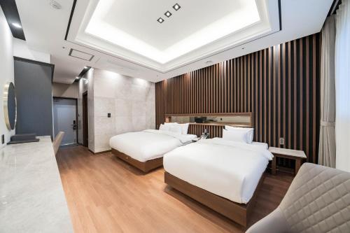 a hotel room with two beds and a skylight at Hotel Demer Mokpo in Mokpo