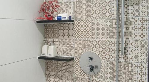 a bathroom with a mirror on a tiled wall at Căn hộ Condotel 5 sao Apec Mandala Phú Yên in Tuy Hoa