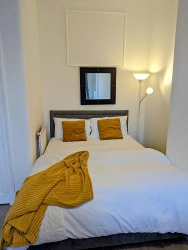 a bedroom with a large white bed with orange pillows at Ensuite Room In The City in Edinburgh