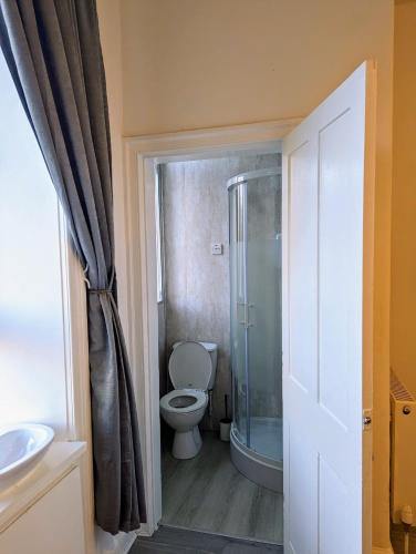 a bathroom with a toilet and a shower and a sink at Ensuite Room In The City in Edinburgh