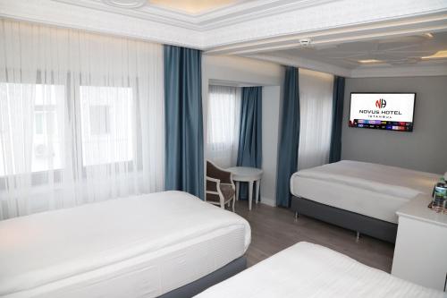 Novus Hotel İstanbul في إسطنبول: غرفة فندقية بسريرين وتلفزيون