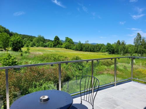 a patio with a table and chairs on a balcony at Domki z jacuzzi Zacisze w Górach in Sosnówka