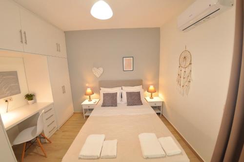 a bedroom with a large bed and two tables and a desk at Villa Eoli Corfu in Ágios Prokópios
