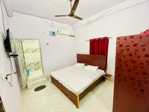 a small bedroom with a bed and a red curtain at Rita Shree Homestay At Ayodhya Highway in Sultānpur