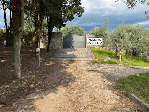 a dirt road with a sign that reads visitor control at Villetta Gabriella in Impruneta