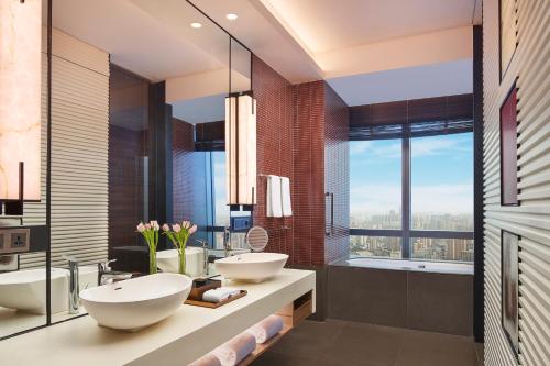 a bathroom with two sinks and a large window at Grand Hyatt Changsha in Changsha