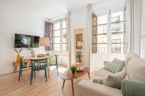 una sala de estar con un sofá y una mesa en Apartamentos Luna Suites Palacio Dorita, en Granada