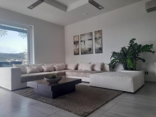 a white living room with a couch and a coffee table at Private Family Villa in Budaörs
