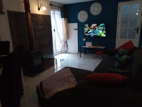 a living room with a couch and a tv at Casa Holmes in Las Casillas