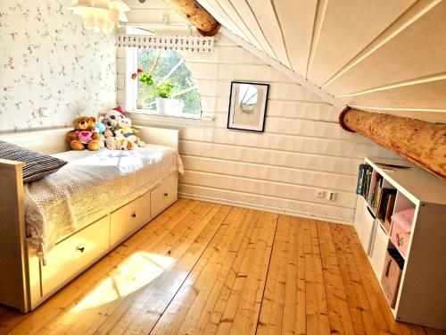 a bedroom with a bed with stuffed animals on it at Timber house with private beach and boat including. in Njurundabommen