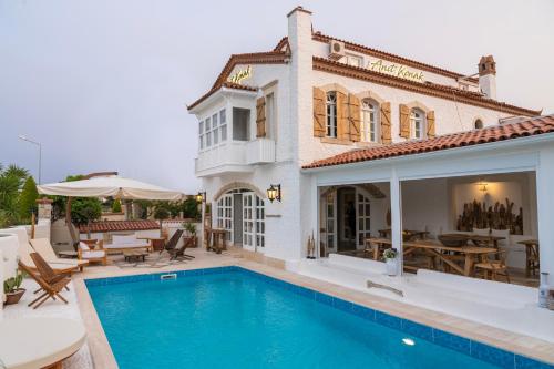 a house with a swimming pool in front of a house at Anıt Konak in Alacati